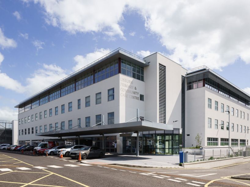 Located adjacent to the listed maternity building within the Lagan Valley Hospital complex, the design comprises a four storey building and adjacent car park on the steeply sloping site, set on a plinth which integrates into the ground at the main entrance.